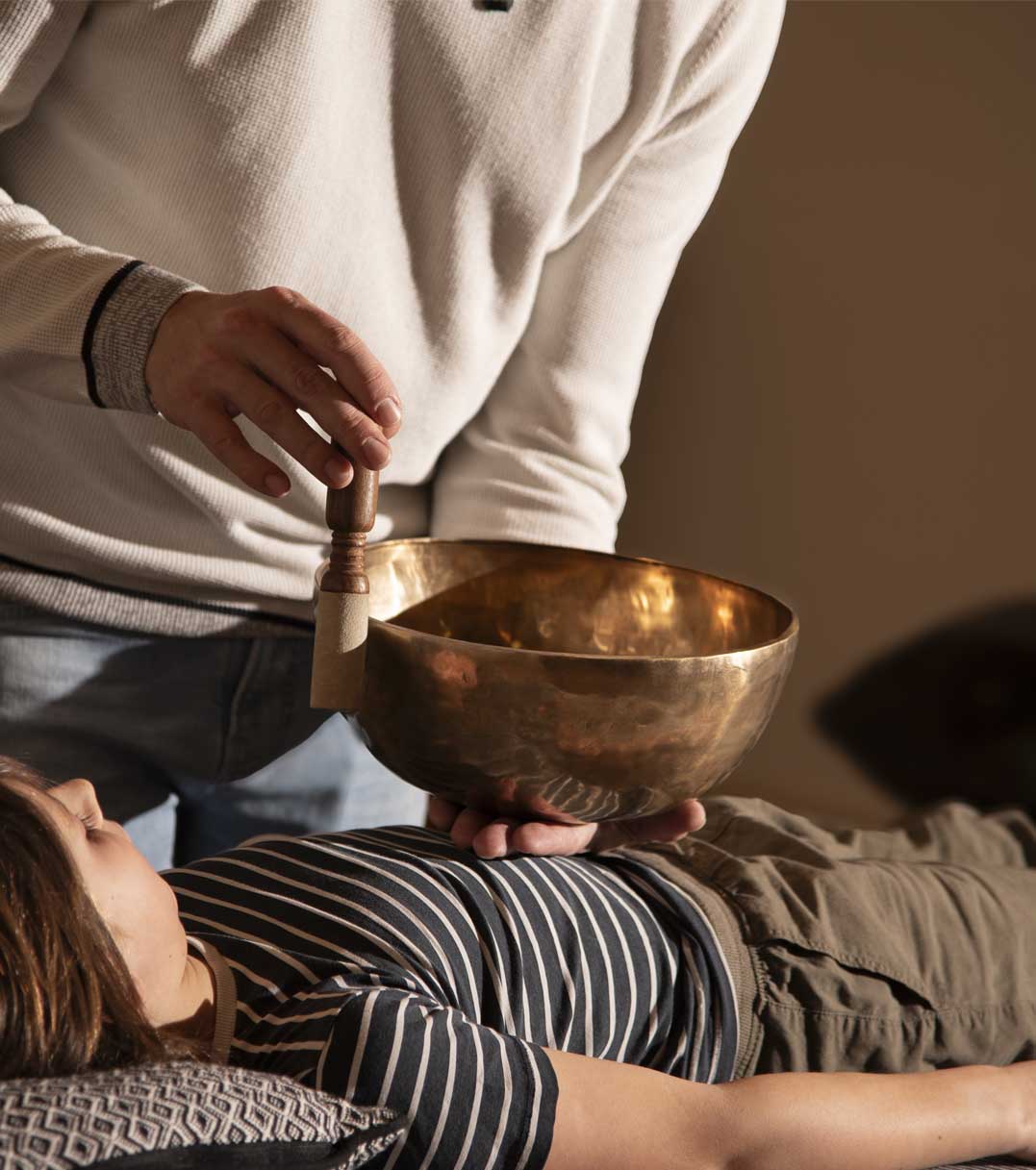 Sébastien Leblanc utilisant un bol tibétain lors d'un soin sensoriel alliant hypnose, odeurs et son pour une relaxation et une détente profonde.